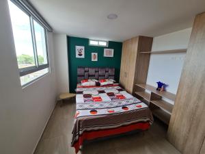 1 dormitorio con 1 cama en una habitación con paredes verdes en Apartamento Completo Ibague - Parqueadero - Ocobo, en Ibagué
