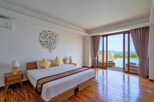 a bedroom with a large bed and a balcony at Vivo Villas - Villa Vivo in Uluwatu +41 photos