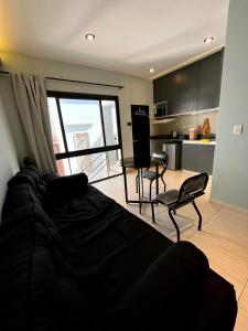 1 dormitorio con 1 cama y sillas y cocina en Departamentos Muskuy - Salta Capital en Salta