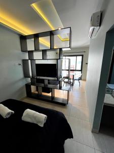a bedroom with a black bed and a television at Departamentos Muskuy - Salta Capital in Salta