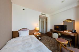 um quarto de hotel com uma cama e uma secretária em Hotel Crescent Asahikawa em Asahikawa