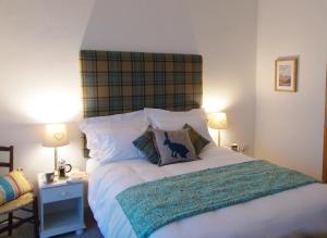 a bedroom with a large white bed with two lamps at The Barn At Collacott in North Petherwin