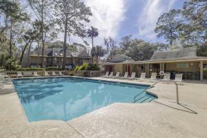 ヒルトン・ヘッド・アイランドにあるLuxury 3 BR 35 BA New kitchen 2 Kings 2 Twins Bikes & Beach Gear includedの椅子と家のあるプール