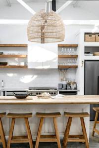 a kitchen with a wooden counter with stools at Soul of Gerringong Cottage in Gerringong