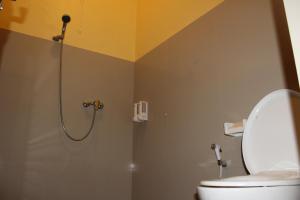 a bathroom with a shower with a toilet in it at Desa Hostel in Munduk