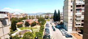 una strada cittadina con auto parcheggiate in un parcheggio di Apartment Cape a Podgorica