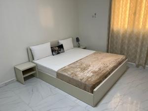 a bedroom with a large bed with a night stand at 1704 Najah Tevragh Zeina in Nouakchott