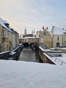 a river in a city covered in snow at Le Chalet de St Vigor in Saint-Vigor-le-Grand