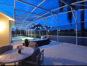a patio with a table and chairs and a pool at Entire home with pool and lake view and Golf course by Disney in Davenport