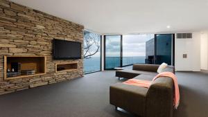 a living room with a couch and a stone wall at Sea Ranch in Wye River
