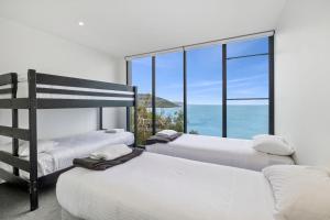three beds in a room with a view of the ocean at Cape Wye in Wye River