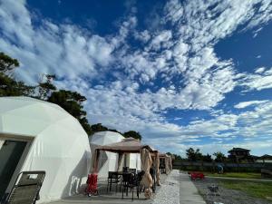 a row of tents with a blue sky and clouds at ポセイドン グランピング Poseidon Glamping in Kujukuri