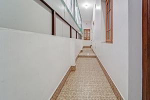 a corridor of a building with white walls and a tile floor at Collection O Ark Residency in Irugūr