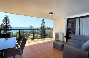 a living room with a view of the ocean at Coral Sands Penthouse in Bargara