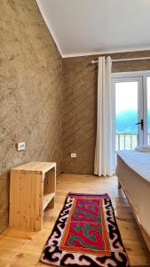 ein Schlafzimmer mit einem Bett und einem Teppich auf dem Boden in der Unterkunft Altay Village Hotel 