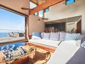 a living room with a couch and a large window at &SUN Penthouse in Yokosuka