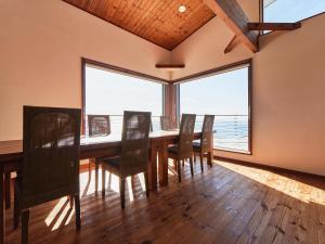 a dining room with a table and chairs and a large window at &SUN Penthouse in Yokosuka