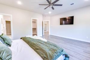 a white bedroom with a bed and a ceiling fan at NEW Classic Cozy Gem *Med/NRG* in Houston