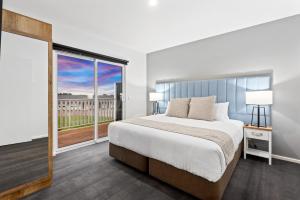 a bedroom with a large bed and a large window at Sanctuary Inn on Westernport in Hastings