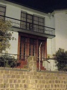 een wit huis met een houten deur en trap bij casa completa en alquiler in Quito