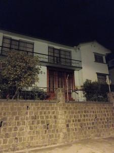 een groot wit huis met een bakstenen muur bij casa completa en alquiler in Quito