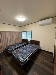 two mattresses in a room with two beds at 下呂スプリングスロッジ in Gero