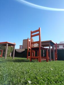 a group of chairs sitting in the grass at Il Point Hostel Cafe in Neuquén