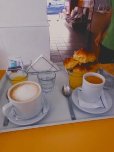 a tray with two cups of coffee and pastries on it at Il Point Hostel Cafe in Neuquén