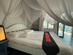 um quarto com uma cama com cortinas brancas em Blu oceano B&B, Italian restaurant em Nembrala