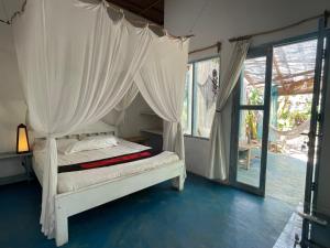 a bedroom with a bed with a canopy at Blu oceano B&B, Italian restaurant in Nembrala
