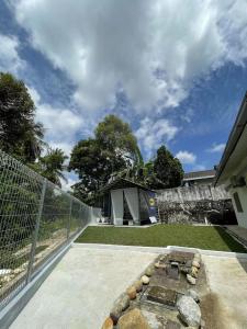 a backyard with a fire pit and a fence at Kiri Kanan Bukit Homestay Kuala Kubu Bahru 左林右舍 in Kuala Kubu Baharu