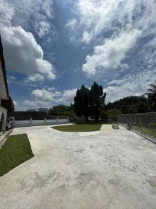 un grande patio in cemento con un albero sullo sfondo di Kiri Kanan Bukit Homestay Kuala Kubu Bahru 左林右舍 a Kuala Kubu Baharu