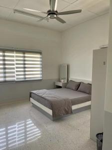 a bedroom with a bed and a ceiling fan at Kiri Kanan Bukit Homestay Kuala Kubu Bahru 左林右舍 in Kuala Kubu Baharu