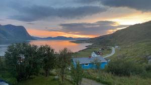 una casa su una collina vicino a un corpo d'acqua di GuestHouse Seiland a Skakkebakken