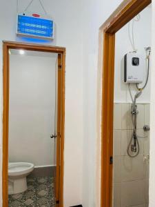 ein Badezimmer mit einem WC und einer Box an der Wand in der Unterkunft 3 Sisters Guest House 1 in Moalboal