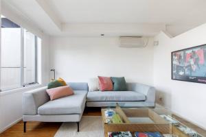 uma sala de estar com um sofá e uma mesa em 'Melbourne Chic on Russell' Cosy City Living em Melbourne
