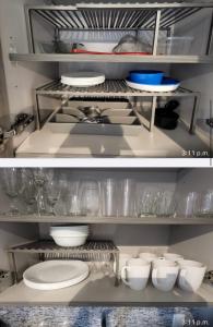- une étagère de cuisine avec des assiettes, des bols et de la vaisselle dans l'établissement 5350 Park inn Suite, à Miami