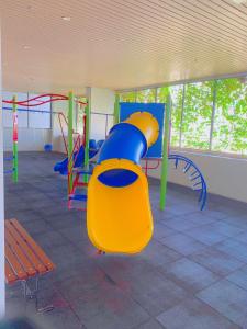 a playground with a blue and yellow slide in a room at Atlantis Residence Melaka ForMuslims Homestay in Melaka