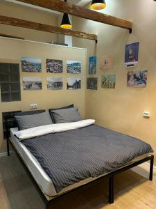 - un lit dans un dortoir avec des photos sur le mur dans l'établissement Noah Apartment, à Tbilissi