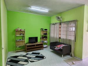 een woonkamer met groene muren en een televisie bij Reyza Homestay KKB in Kuala Kubu Baharu