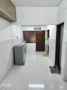 een lege kamer met een kapotte hal met een koelkast bij Reyza Homestay KKB in Kuala Kubu Baharu