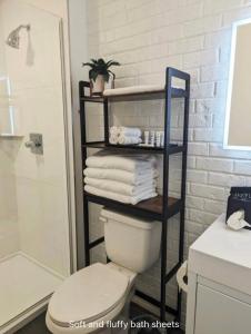 een badkamer met een toilet en een plank met handdoeken bij The Vinyl Suite on Music Row in Nashville