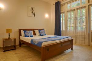 a bedroom with a bed with blue pillows at Kandyan Mount Mirror Boutique Villa in Kandy