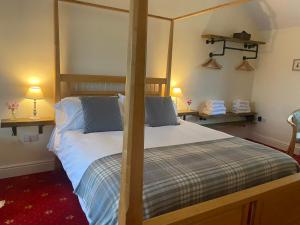 sypialnia z dużym łóżkiem z drewnianą ramą w obiekcie The Gordon Arms Restaurant with Rooms w mieście Yarrow