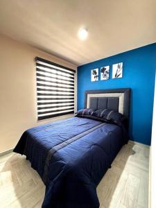um quarto com uma parede azul e uma cama em Nuevo y Hermoso Departamento Pachuca em Mineral de la Reforma