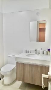 a white bathroom with a toilet and a sink at Exclusivo Hospedaje Moore in Lima