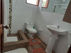 een badkamer met een toilet en een wastafel bij Hosteria SR in Pedernales