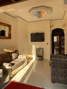 sala de estar con 2 sofás y TV de pantalla plana en Tanger, en Tánger