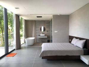 a bedroom with a bed and a tub and a bathroom at Tam Dao Retreat Venuestay in Tam Ðảo