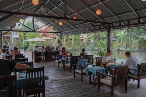 een groep mensen die aan tafel zitten in een restaurant bij Villa Oasis in Luang Prabang